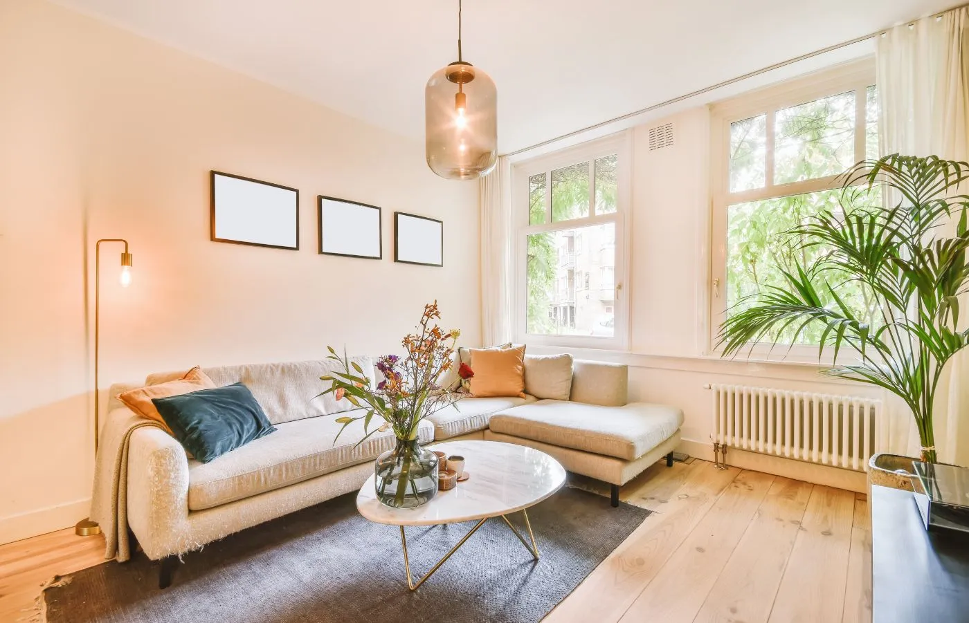 Ambiente luminoso e colorato, con divano moderno, tavolino in marmo, piante e fiori