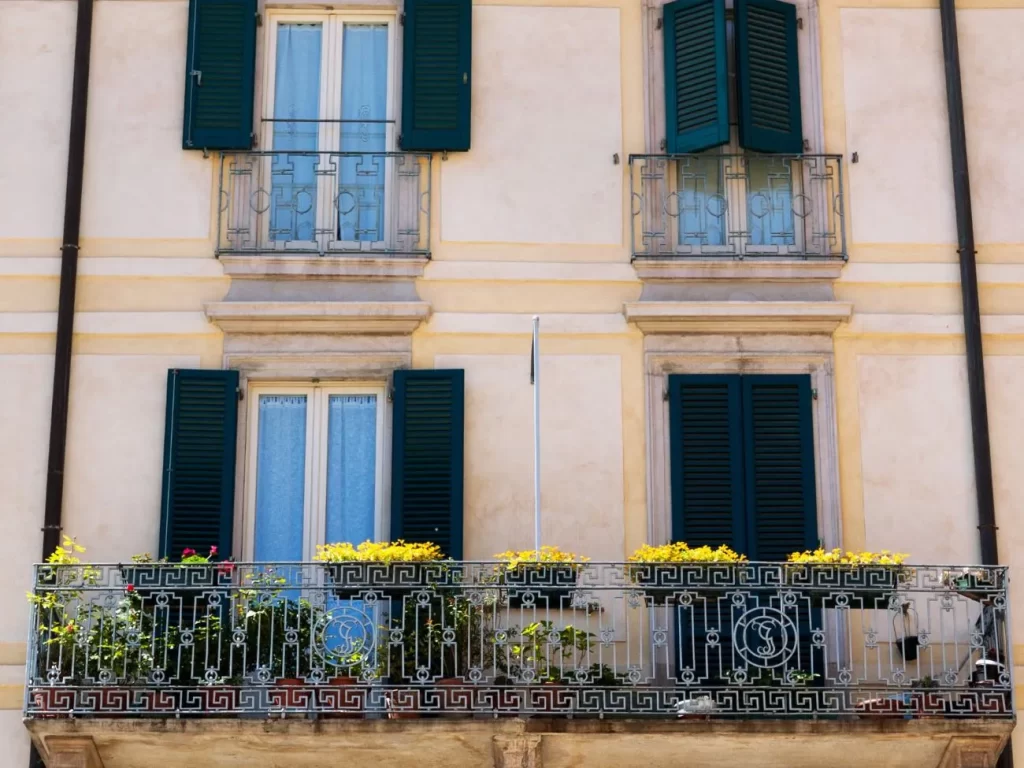 Balcone di un appartamento che si trova in palazzo antico a Varese, probabilmente affacciato su una piazza, con fioriere di fiori